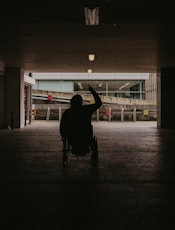 silhouette of person walking on sidewalk during night time