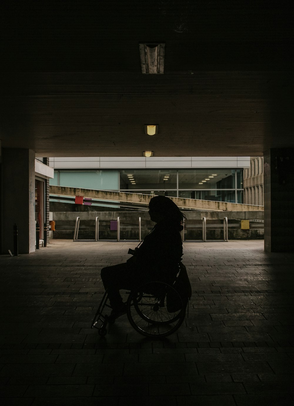 person in black hoodie riding bicycle on sidewalk during night time