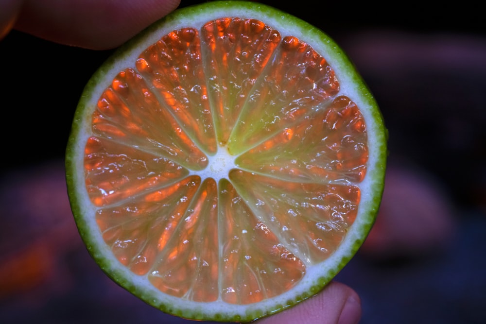 a close up of a person holding a half of a grapefruit
