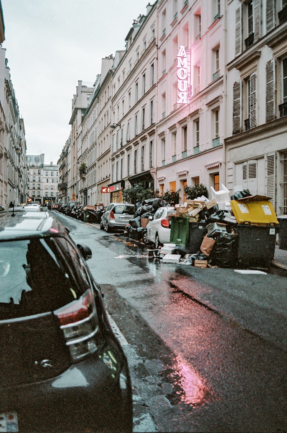 cars parked on street in between buildings during daytime