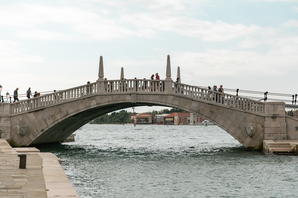 brown concrete bridge over blue sea under white sky during daytime