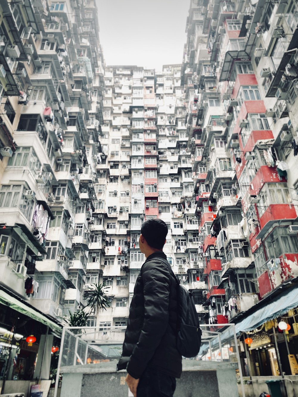 man in black jacket standing in front of building during daytime