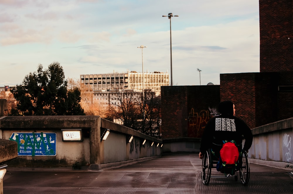 man in black and red jacket riding on bicycle during daytime