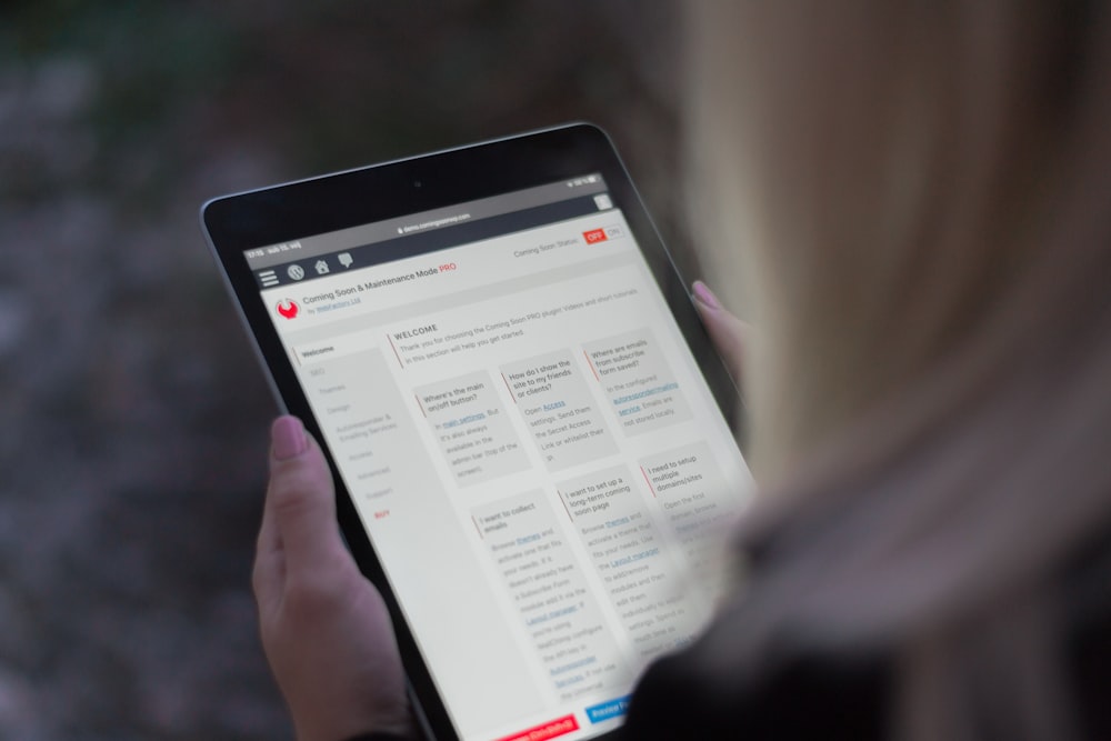 person holding black tablet computer