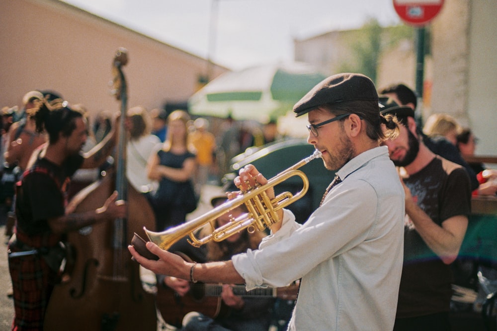 Hombre de blanco thobe tocando la trompeta durante el día