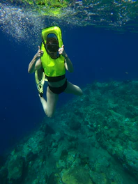 woman in yellow and black bikini swimming in the sea