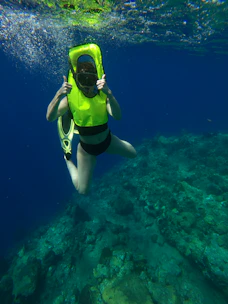 woman in yellow and black bikini swimming in the sea
