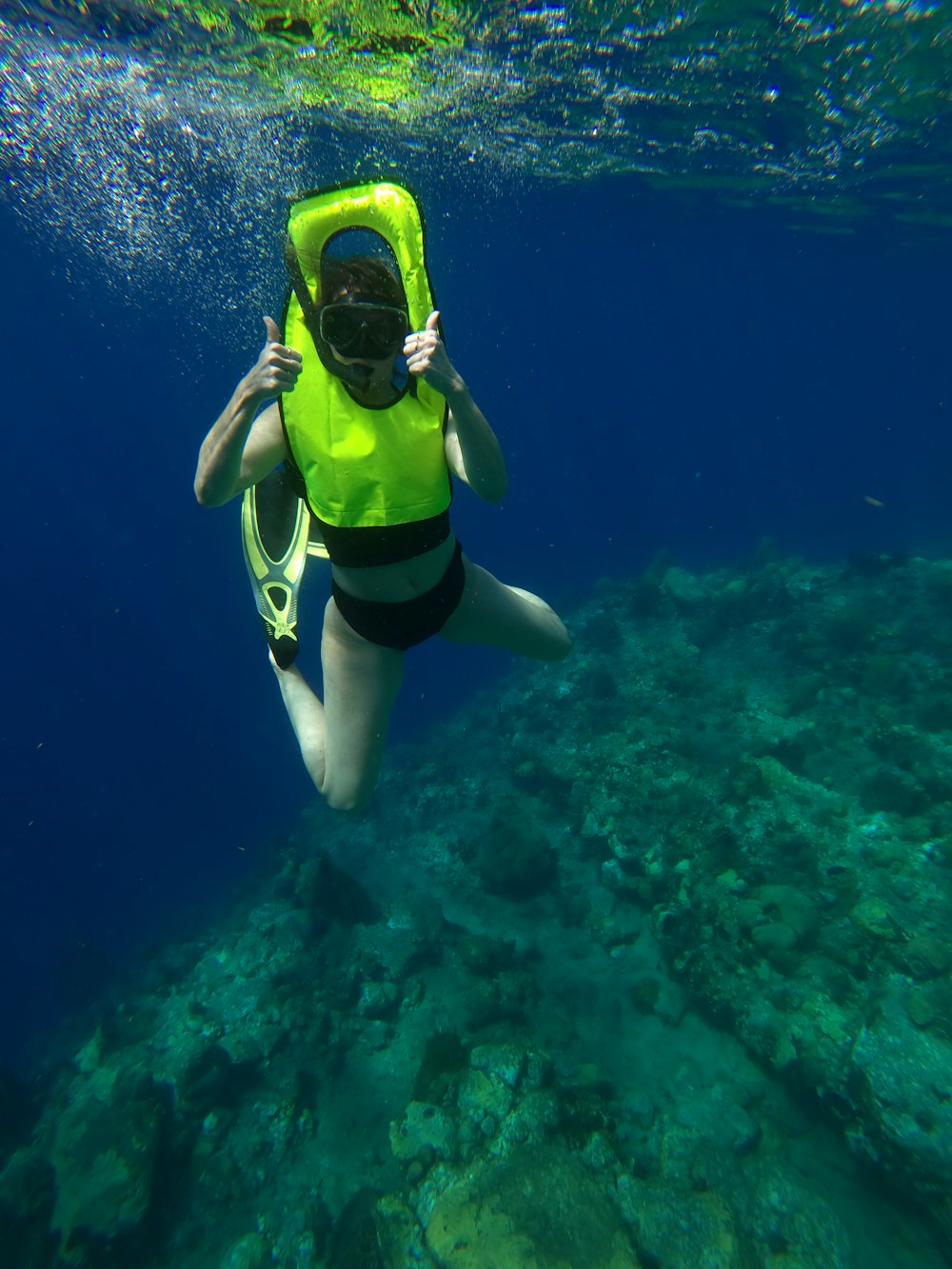 woman in yellow and black bikini swimming in the sea