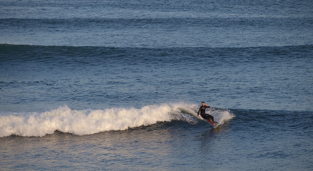 man surfing on sea waves during daytime