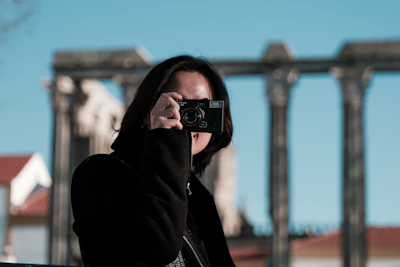 Tourists capturing photos of ancient ruins at sunset.
