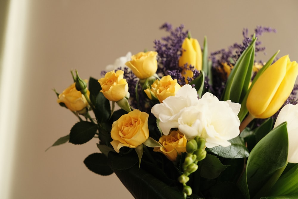 white and yellow flowers on black vase