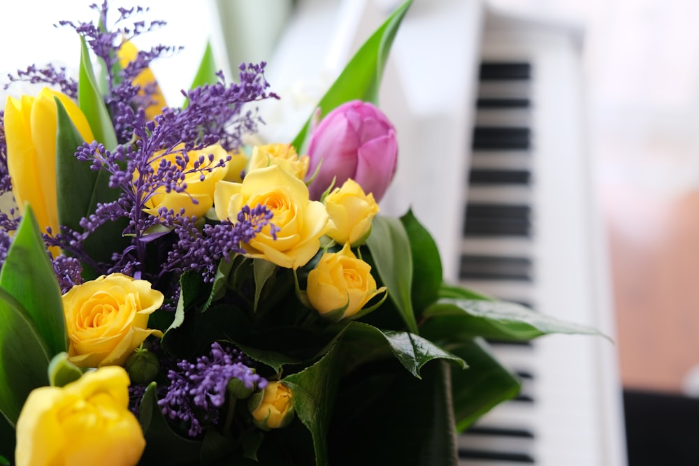 yellow and purple flowers in green vase