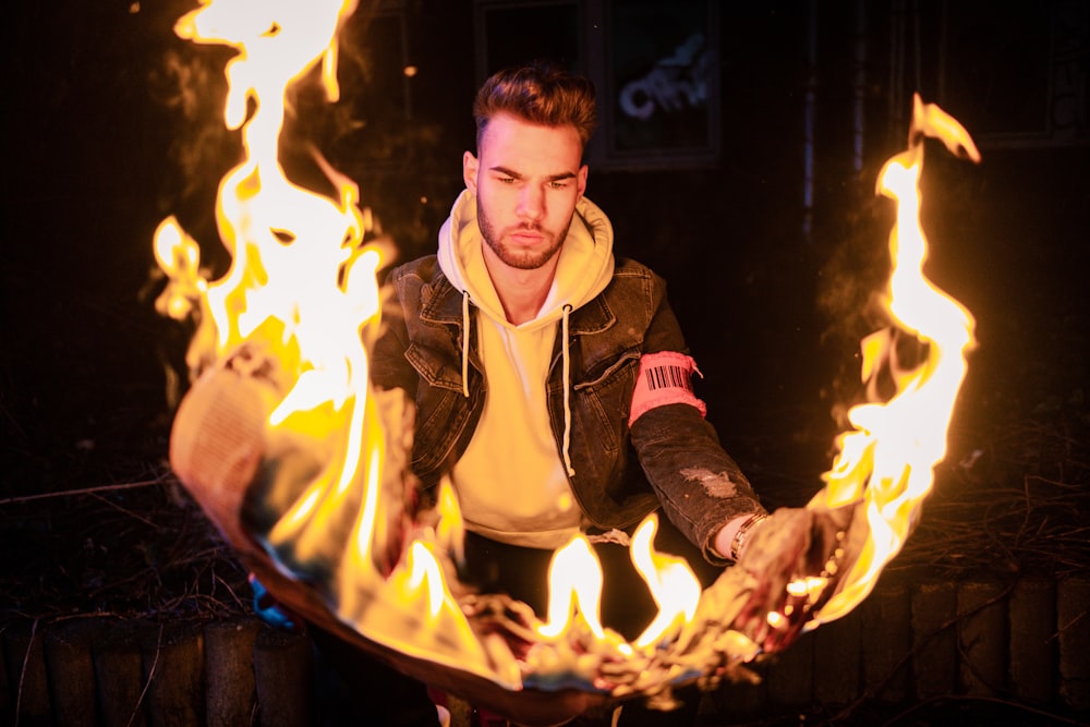 man in brown and black jacket holding fire