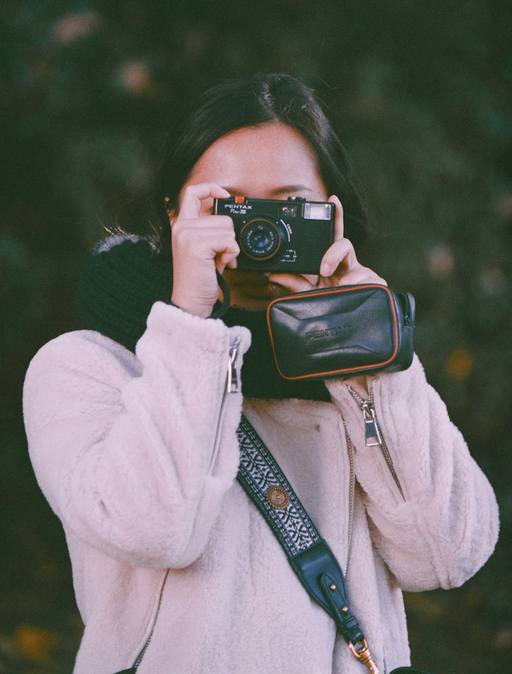 woman in white coat holding black dslr camera