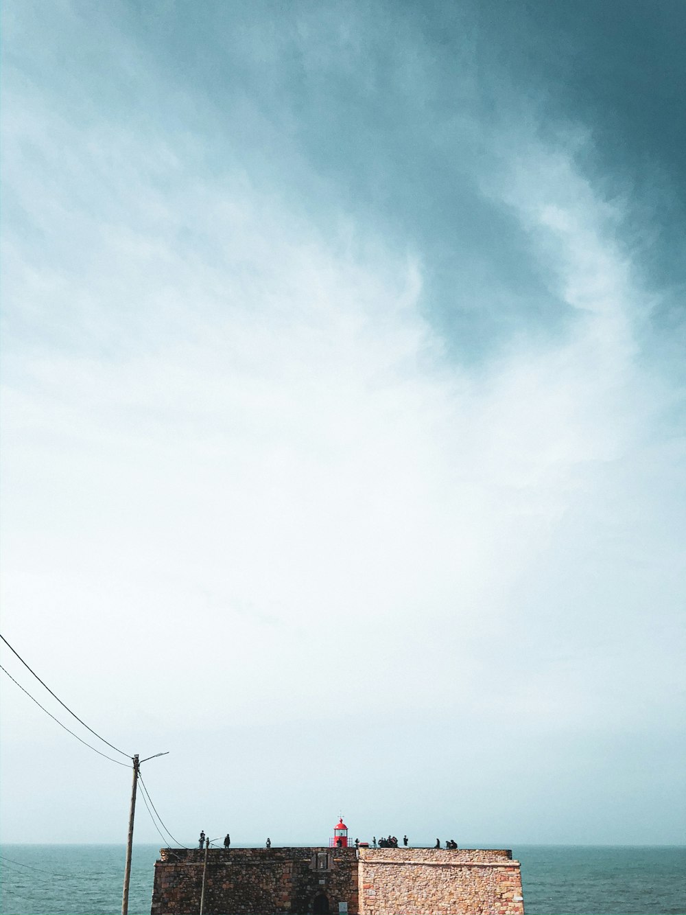 Poste eléctrico negro bajo cielo azul