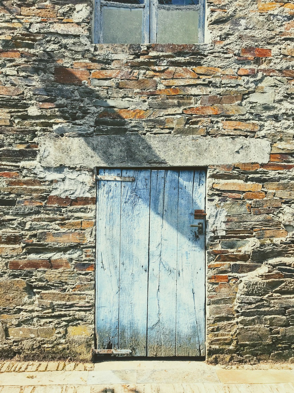 blue wooden door on brick wall