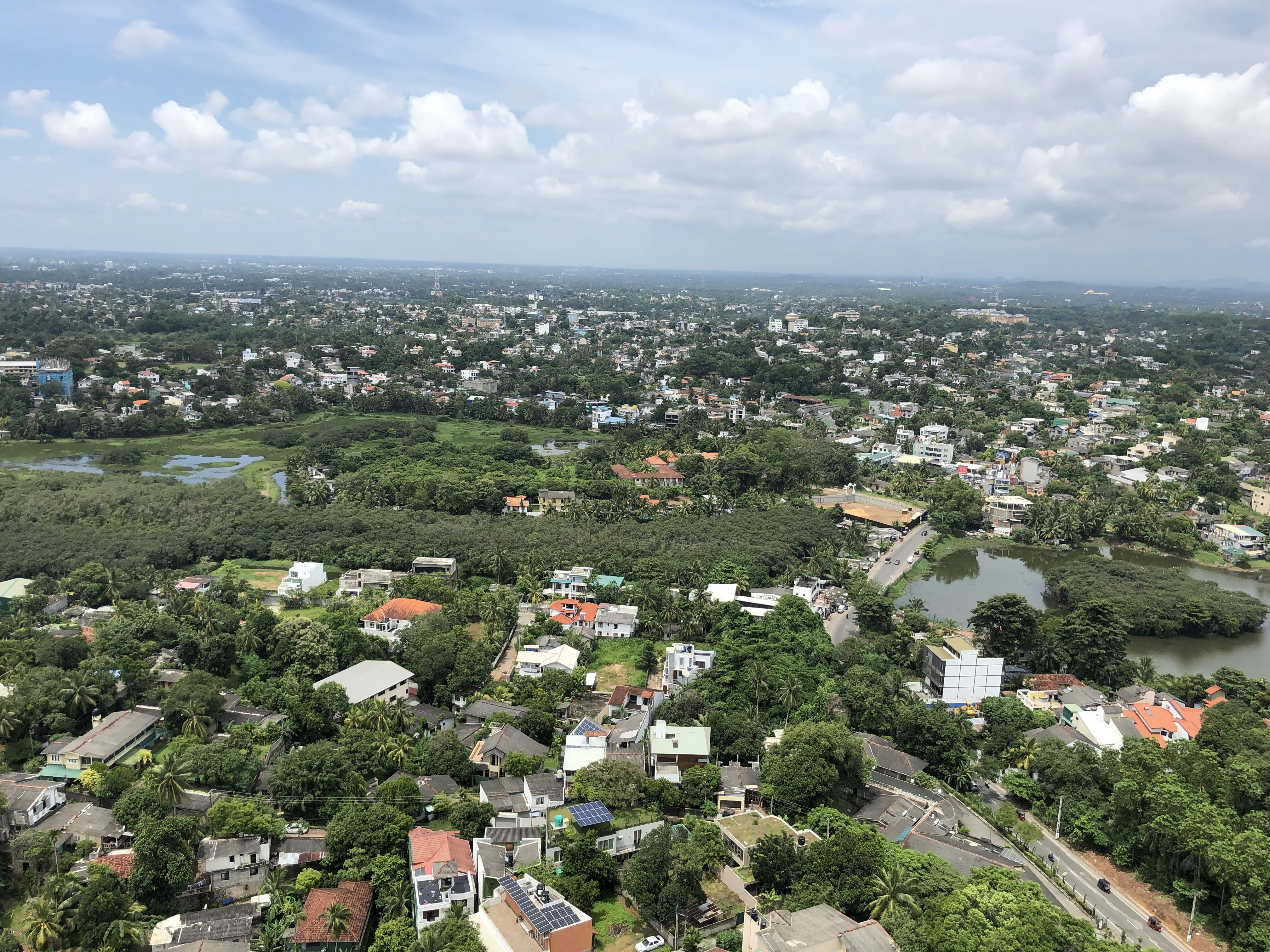 Aerial view of a green Nordic city with parks, cycling paths, and clean waterways — sustainable, livable, human-scale urban design