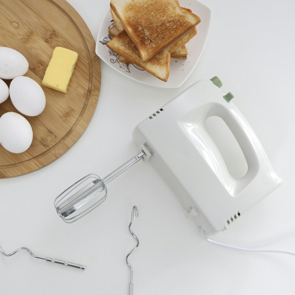 Earpods de pomme blanche à côté du pain sur une plaque en céramique blanche