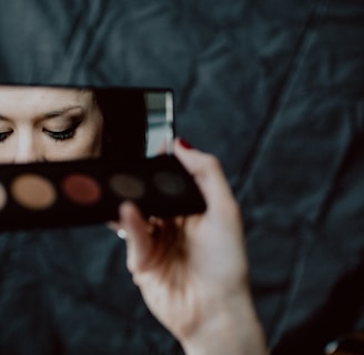 woman holding black and silver make up palette