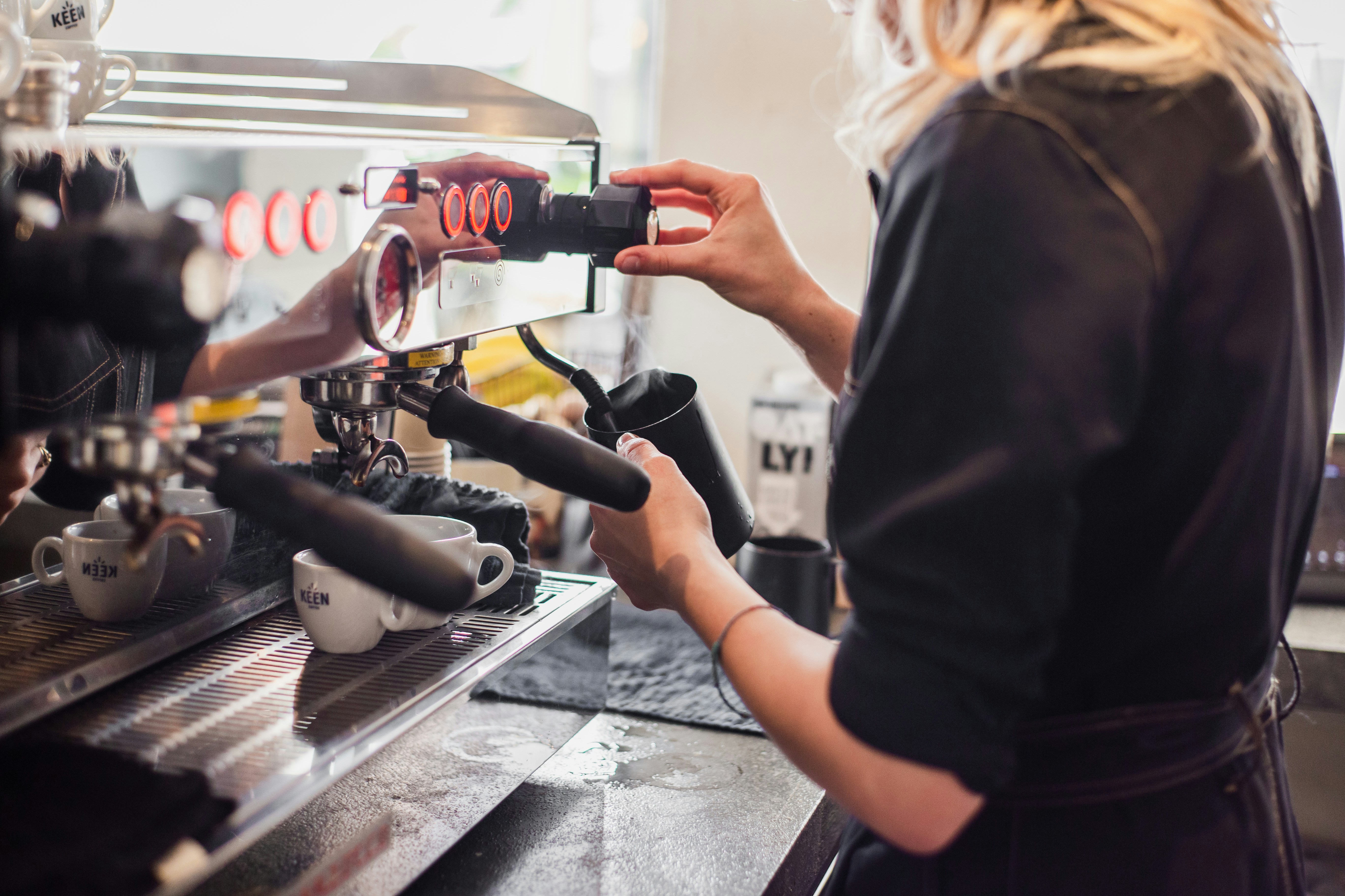 Barista operating an espresso machine group head