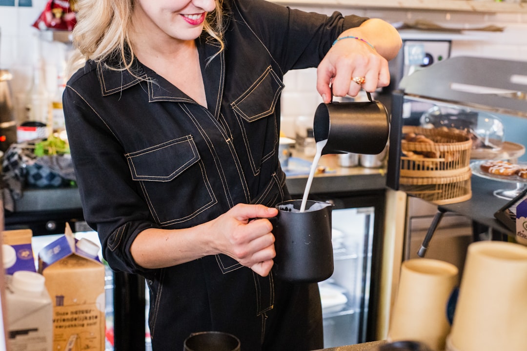 woman in black leather jacket holding black ceramic mug