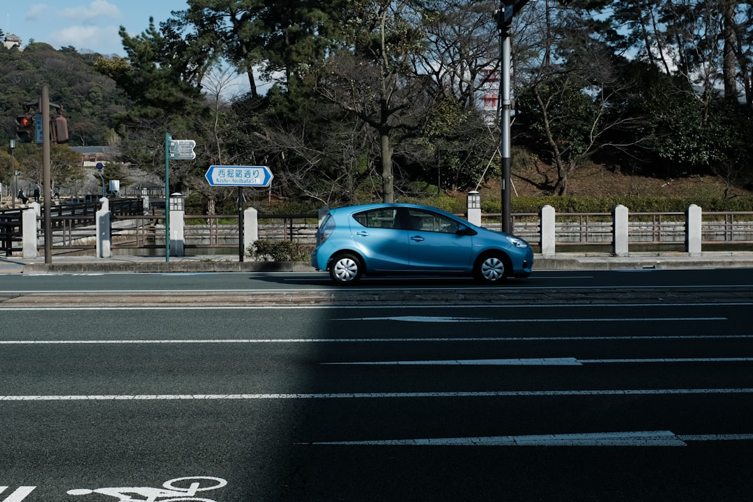 blue 3 door hatchback on road during daytime