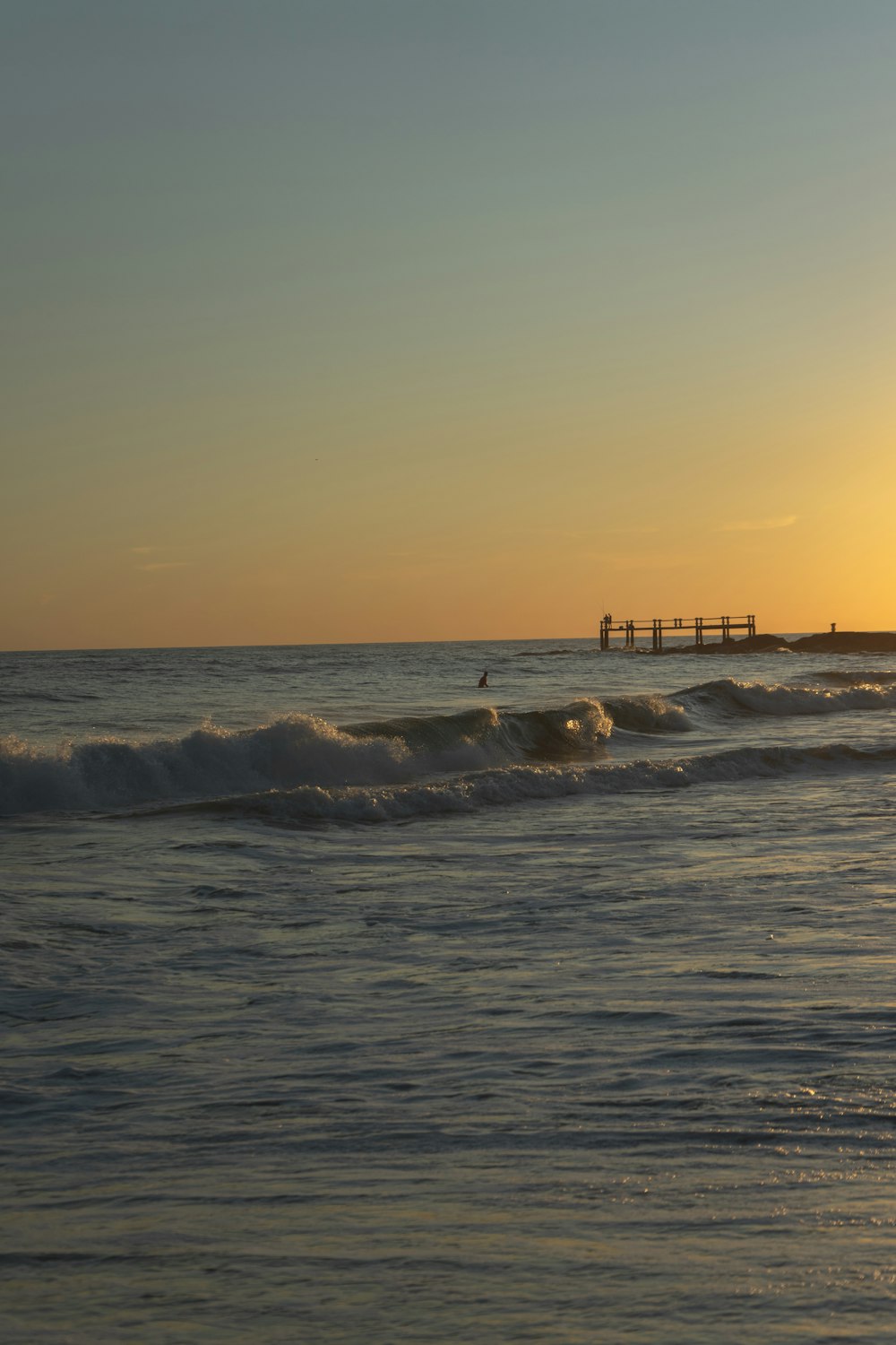 sea waves crashing on shore during sunset