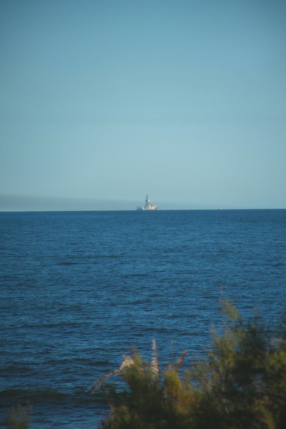 white sailboat on sea under gray sky