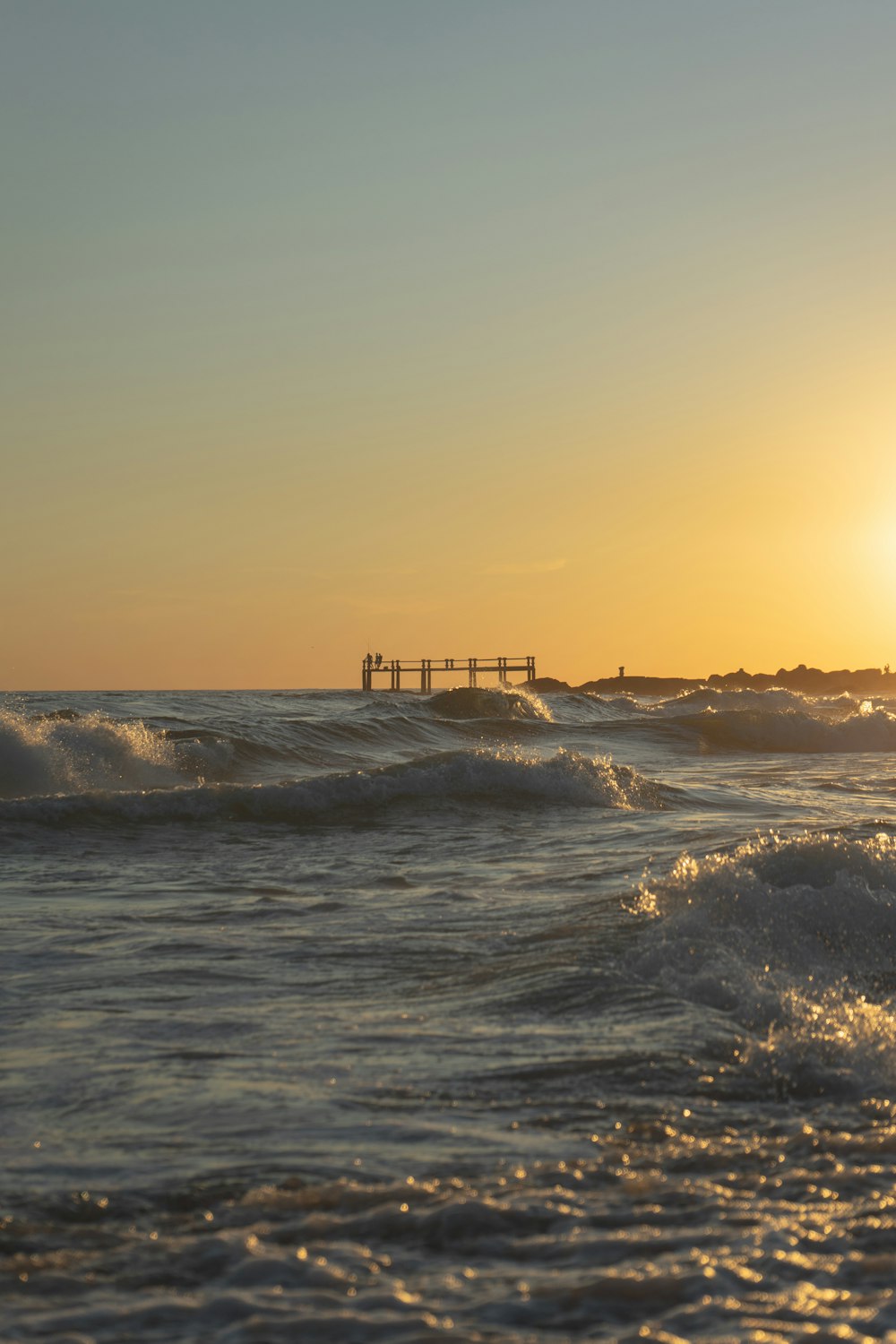 Meereswellen, die bei Sonnenuntergang an Land stürzen