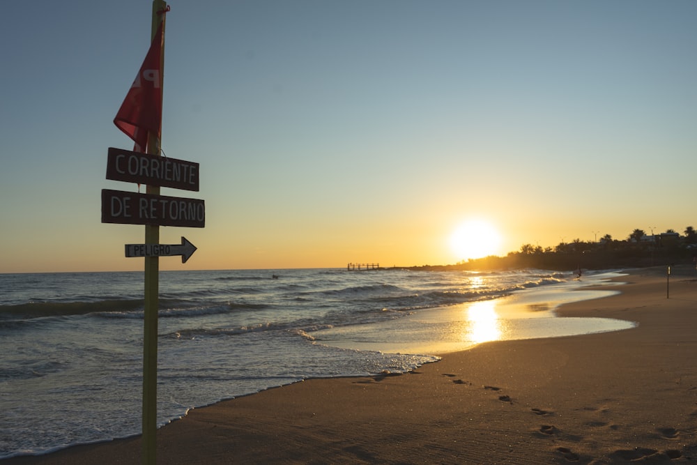 beach signage on beach during sunset