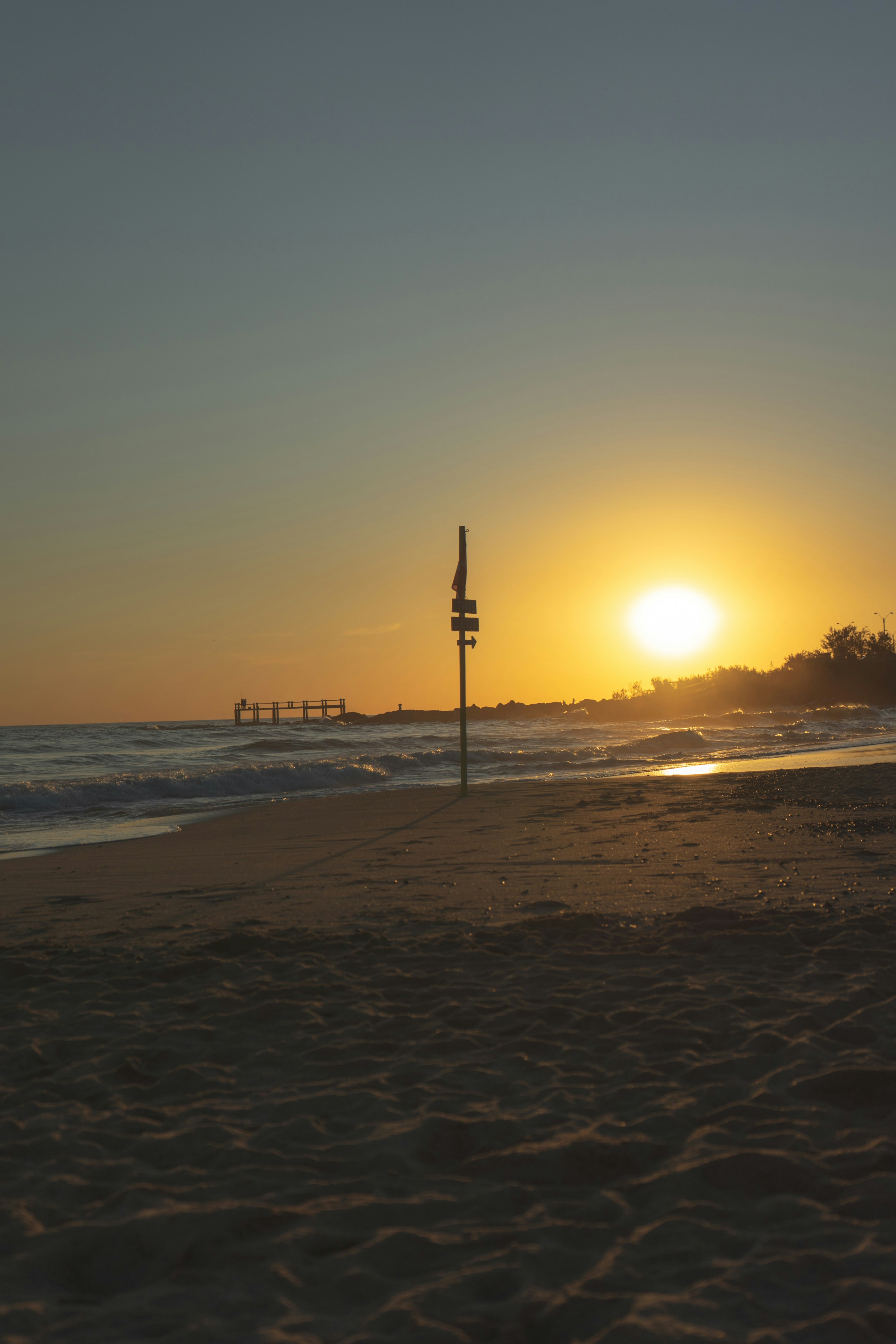 Silhouette von Menschen, die während des Sonnenuntergangs am Strand spazieren gehen