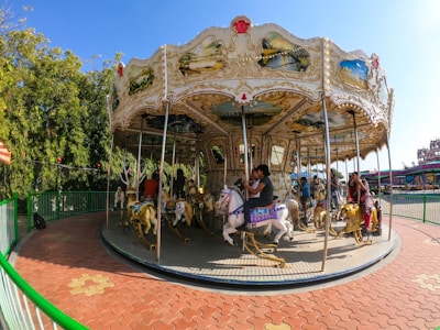 Children laughing while riding a classic Disney carousel.