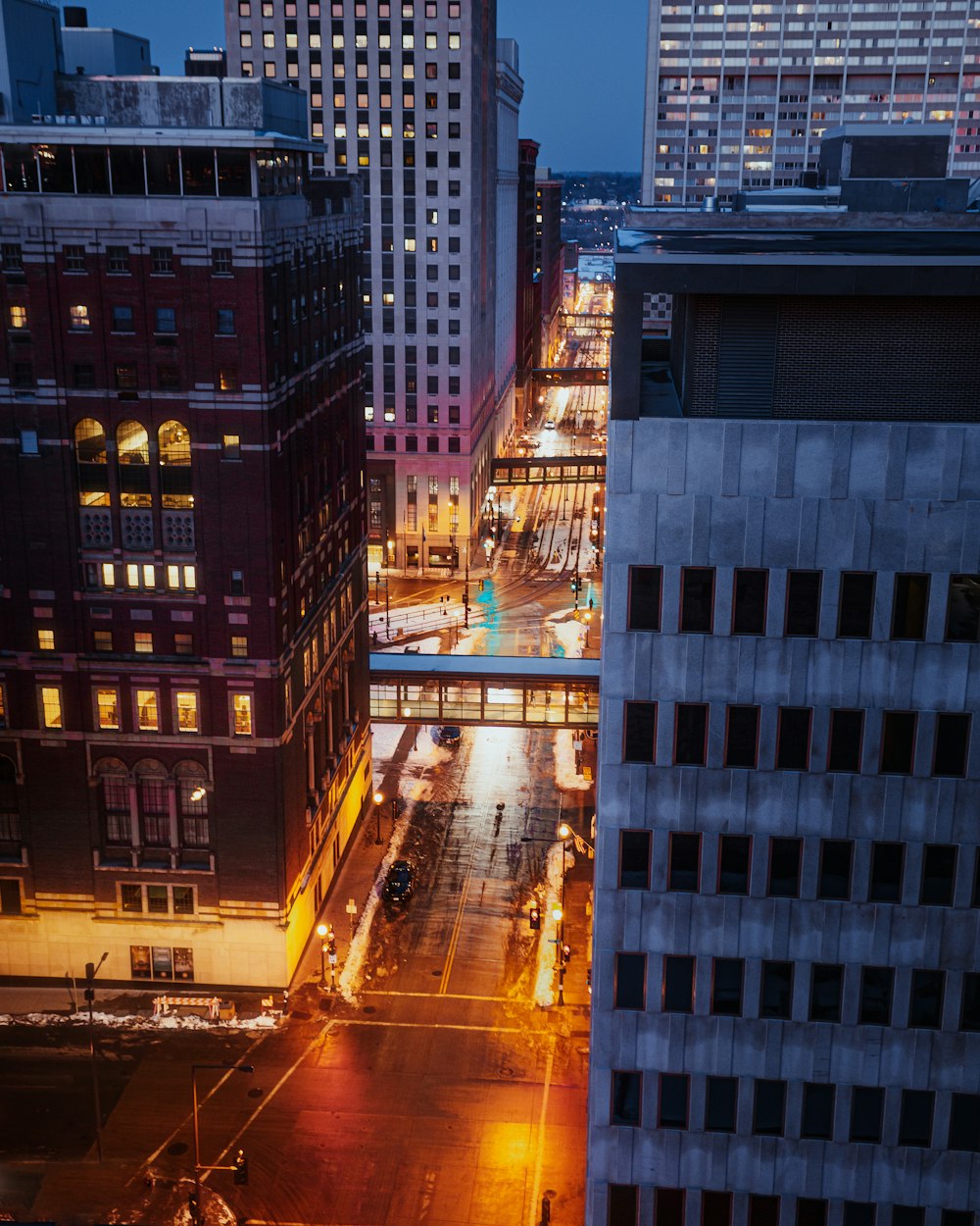 cars on road in between high rise buildings during night time