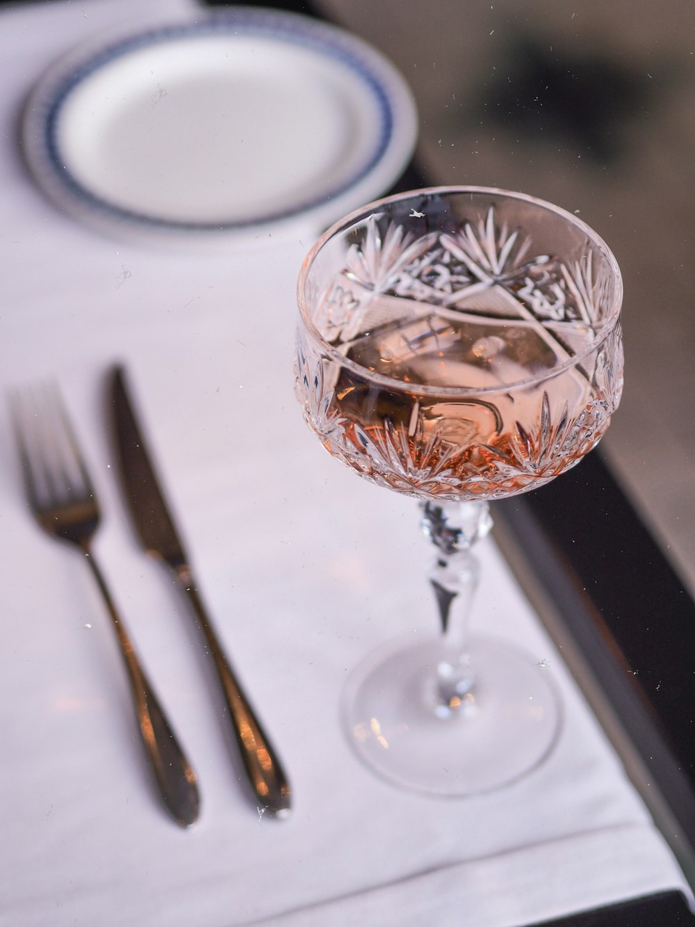 clear wine glass beside silver fork and bread knife