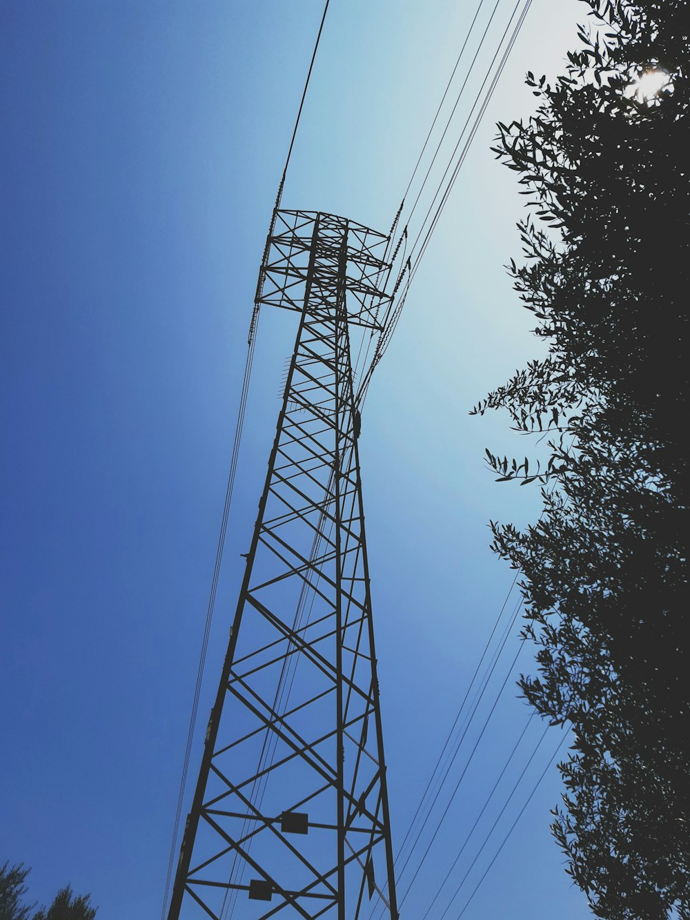 black electric tower under blue sky during daytime