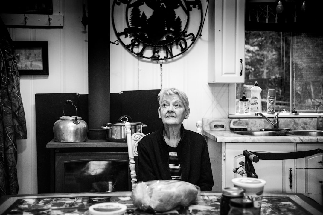 woman in black sweater standing in front of kitchen sink