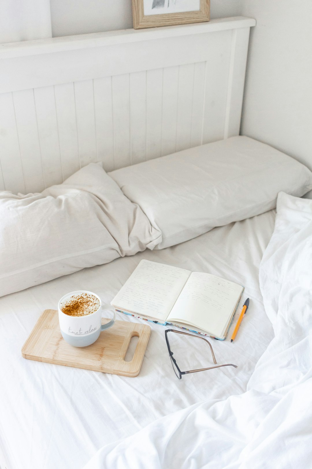 white ceramic mug on brown wooden tray beside white book