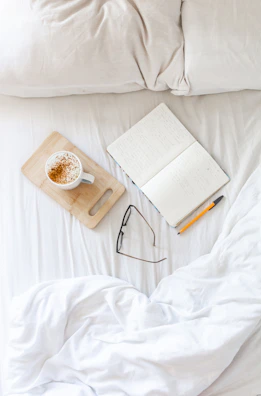 A cozy morning scene with a cup of tea and an open journal on a wooden table.