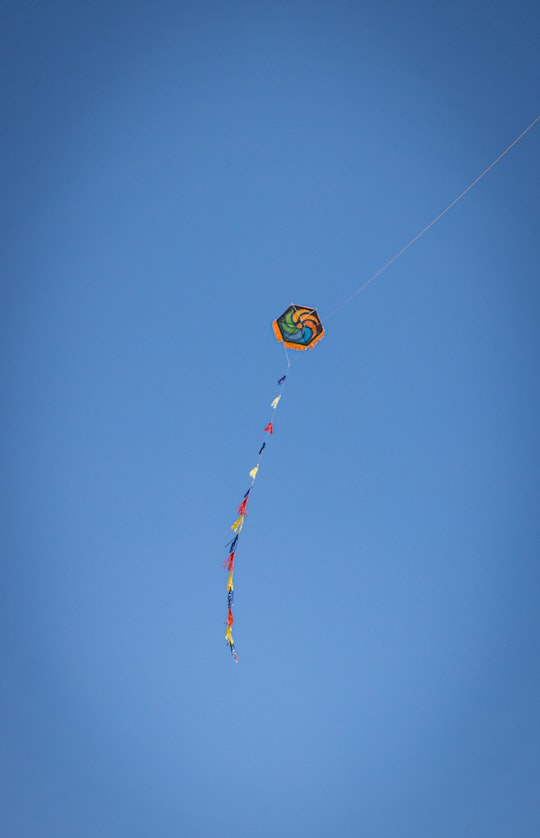 yellow blue and red kite flying under blue sky during daytime in Varkiza Greece