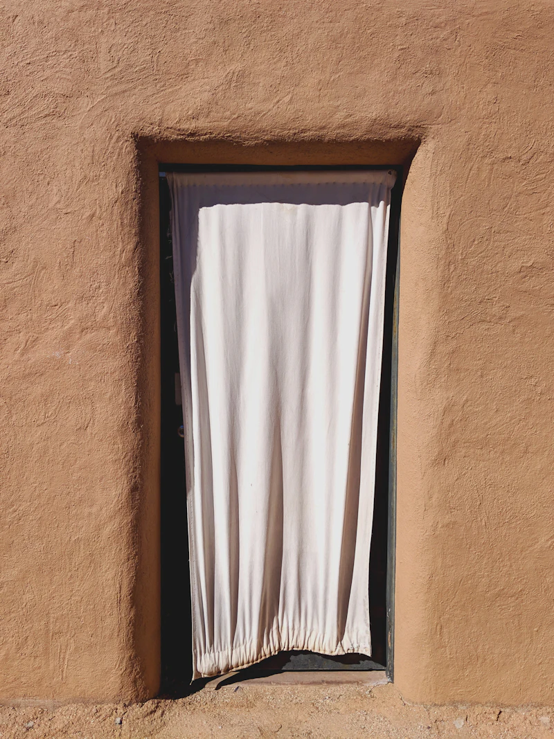 Sunlight through a white curtain in a bedroom