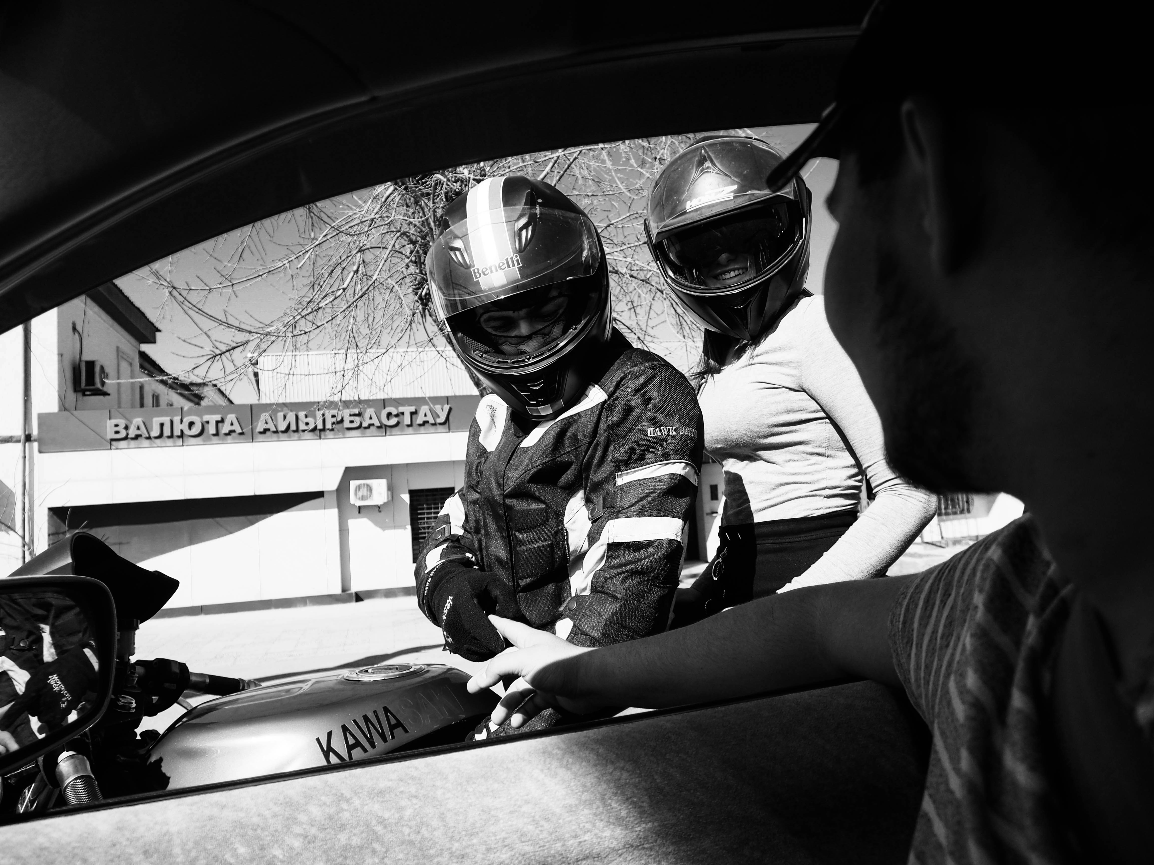 grayscale photo of man in motorcycle helmet and jacket