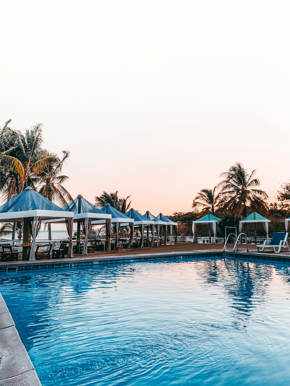 brown wooden gazebo near swimming pool during daytime