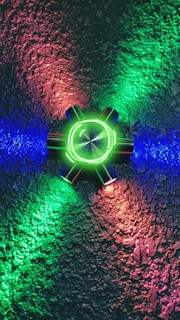 Close-up of a glowing accessory piece resting on a textured surface, casting colorful light.