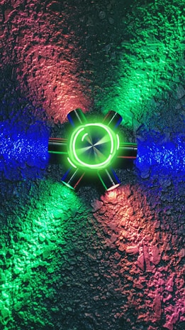 Close-up of a glowing accessory piece resting on a textured surface, casting colorful light.