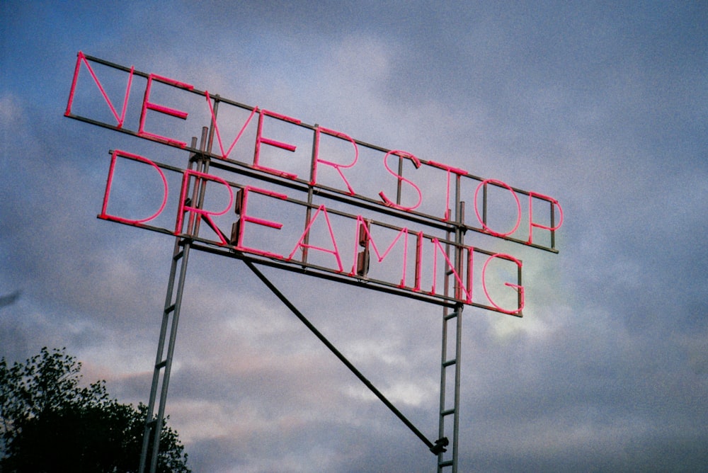 a neon sign that says never stop dreaming
