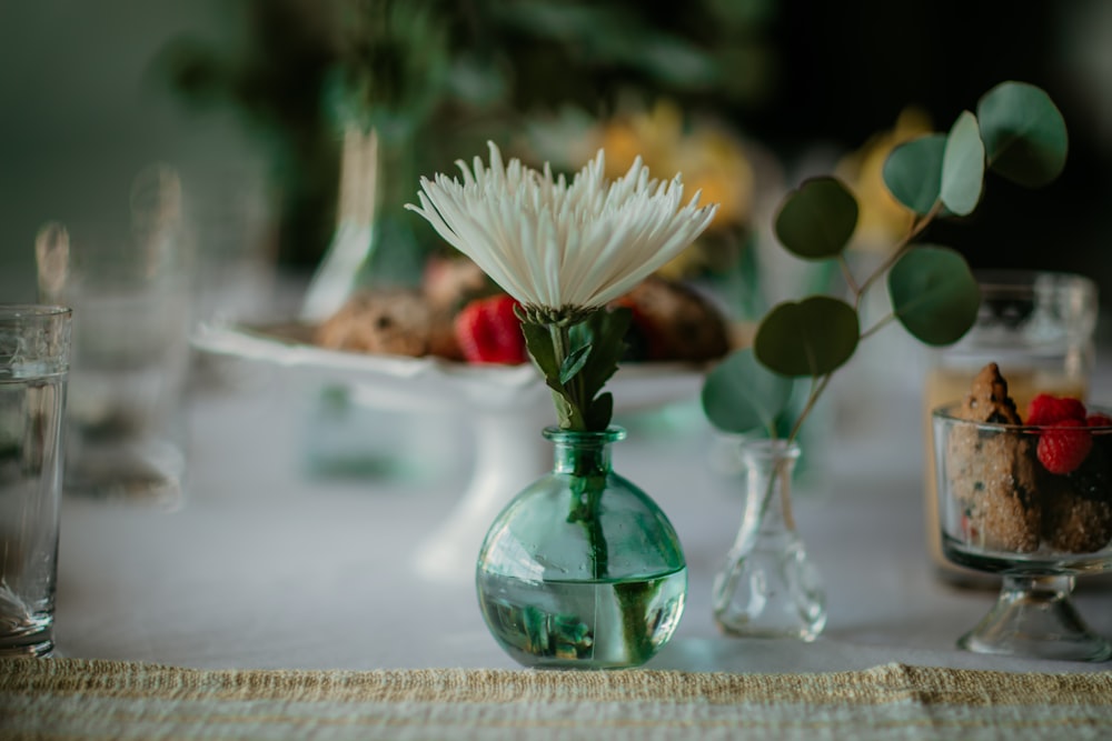 white flower in green glass vase