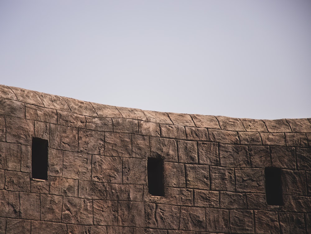 brown brick wall under blue sky during daytime