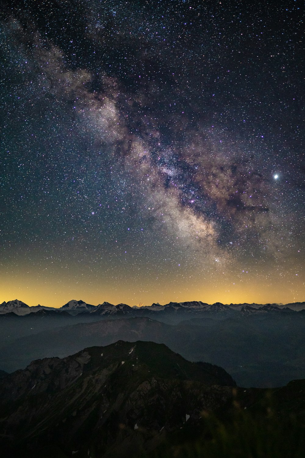 silhouette of mountains under starry night
