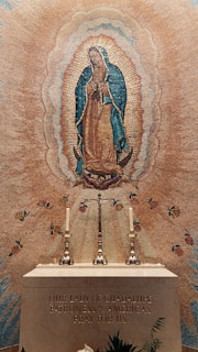 A serene image of the Virgin of Guadalupe surrounded by candles and flowers.