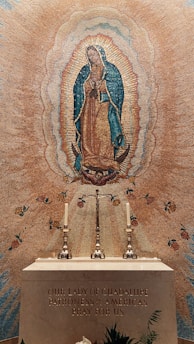 A serene image of the Virgin of Guadalupe surrounded by candles and flowers.